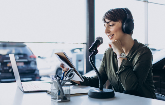 Young woman with microphone recording voice acting